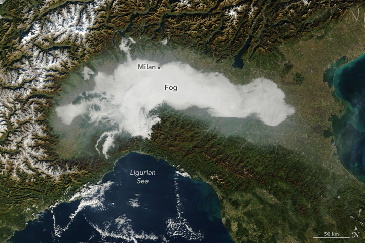 A satellite image shows a patch of fog in the Po Valley in Italy. The fog appears white against the green background of the land.