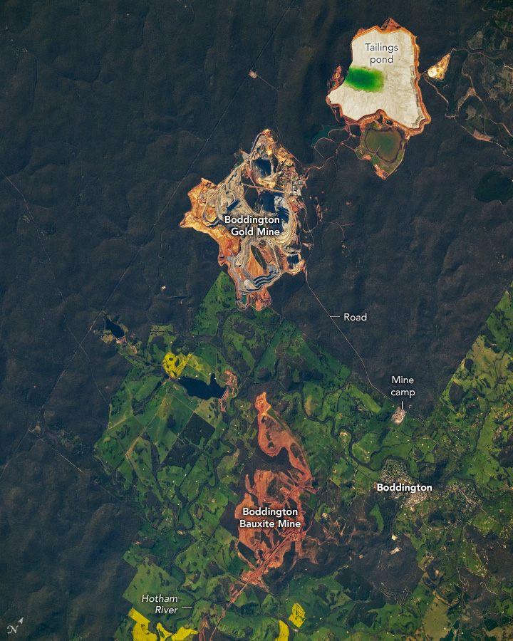 A downward-looking photo shows irregularly shaped red and gold mining areas in the top-middle and bottom-middle. Around the mines, light green agricultural areas transition abruptly into dark green mountainous areas.